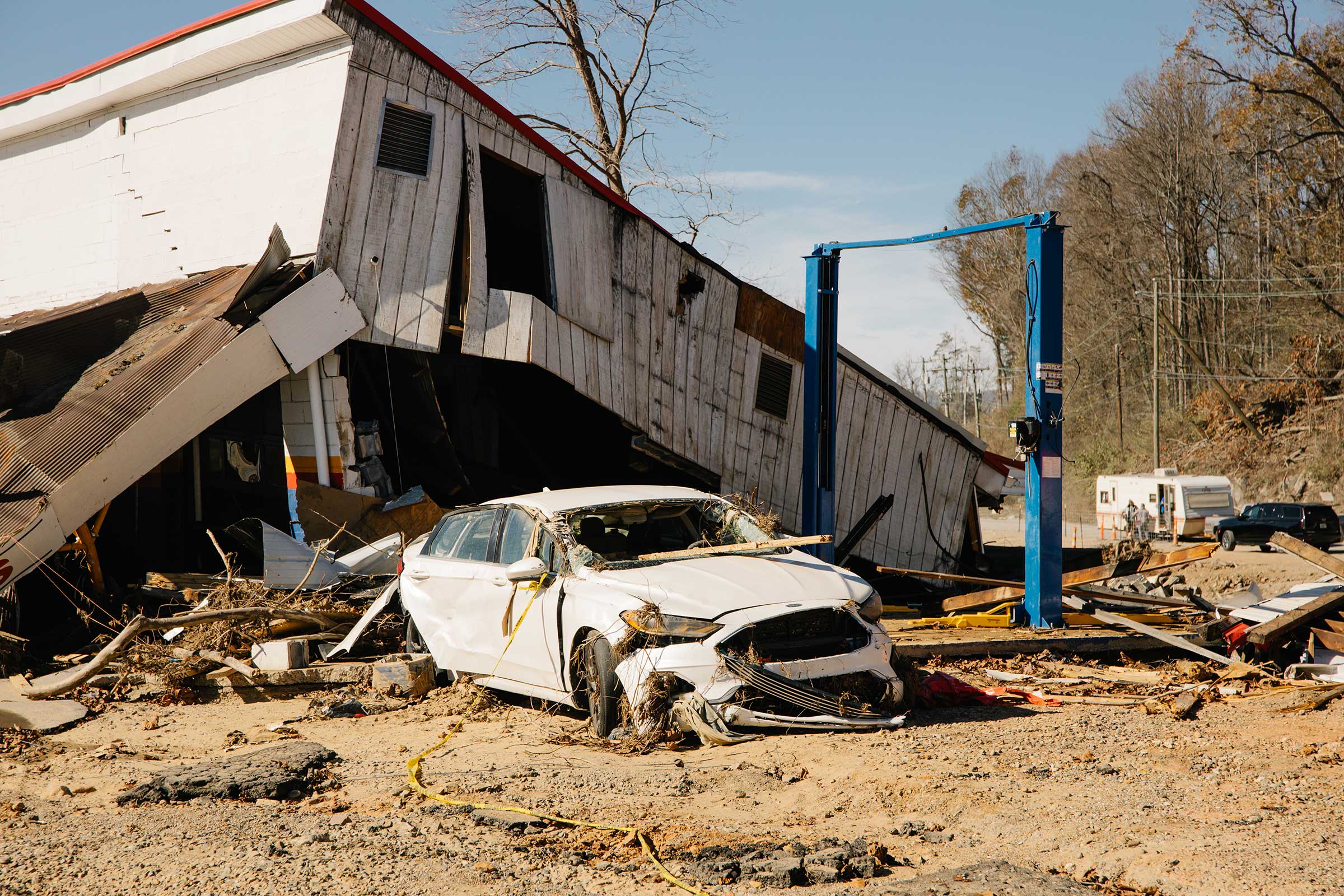 A destroyed car with a house on top of it