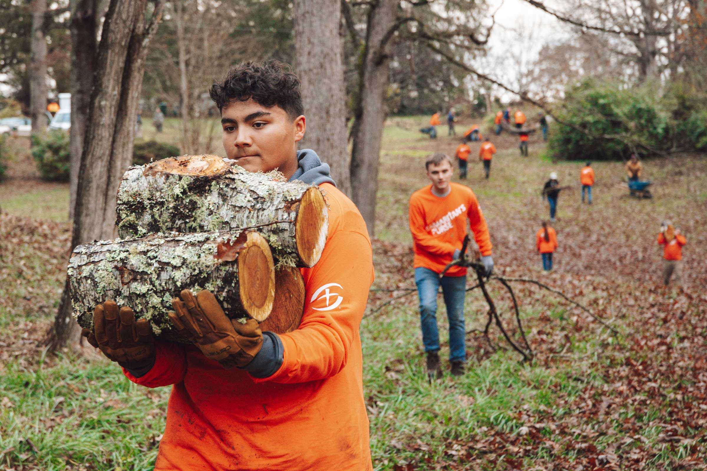 A teen clearing a log